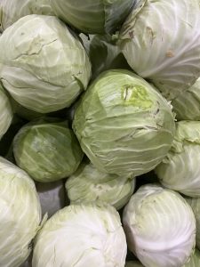
A pile of green cabbages with layered pale green and white leaves.