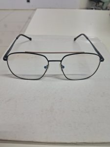 Black-framed eyeglasses resting on a table.
