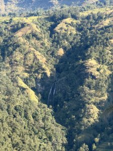 The view of a hill with waterfall at the centre clicked on a sunny weather that reflects the beauty that blends the hill and the waterfall