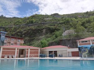 
A swimming pool overlooking lush green hills.