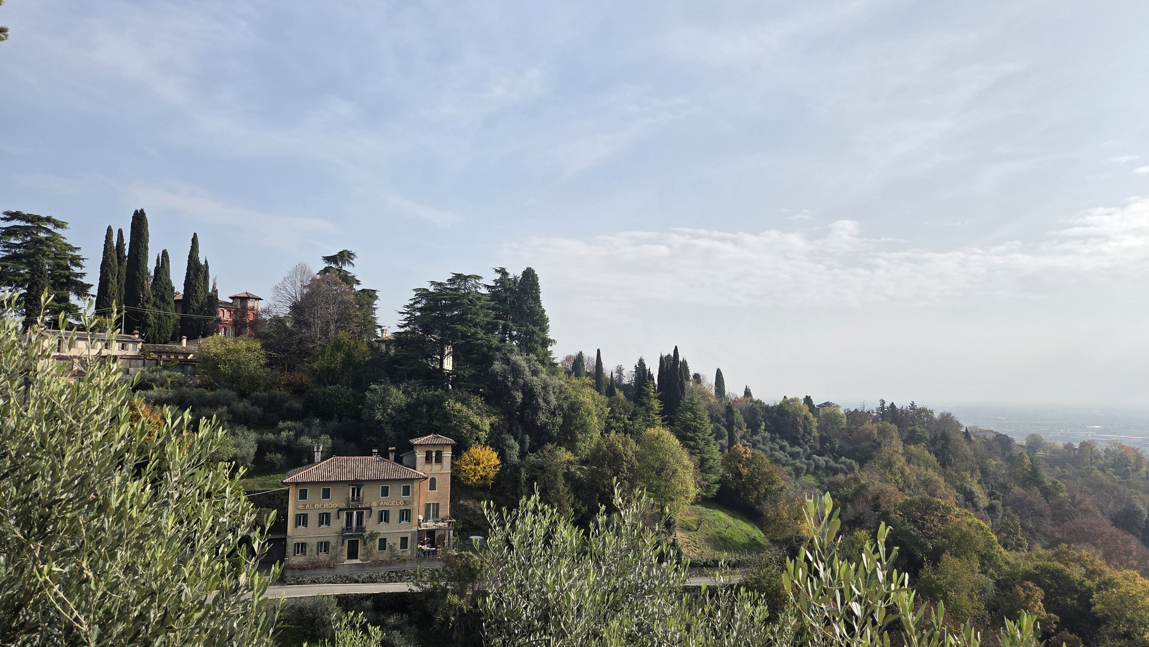 Scenic hillside landscape of Asolo, a historic town in the Veneto region of northern Italy, featuring the classic architecture and olive and cypress trees typical of the area.