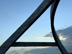 A large, curved concrete structure showcasing modern architectural design against a clear blue sky.
