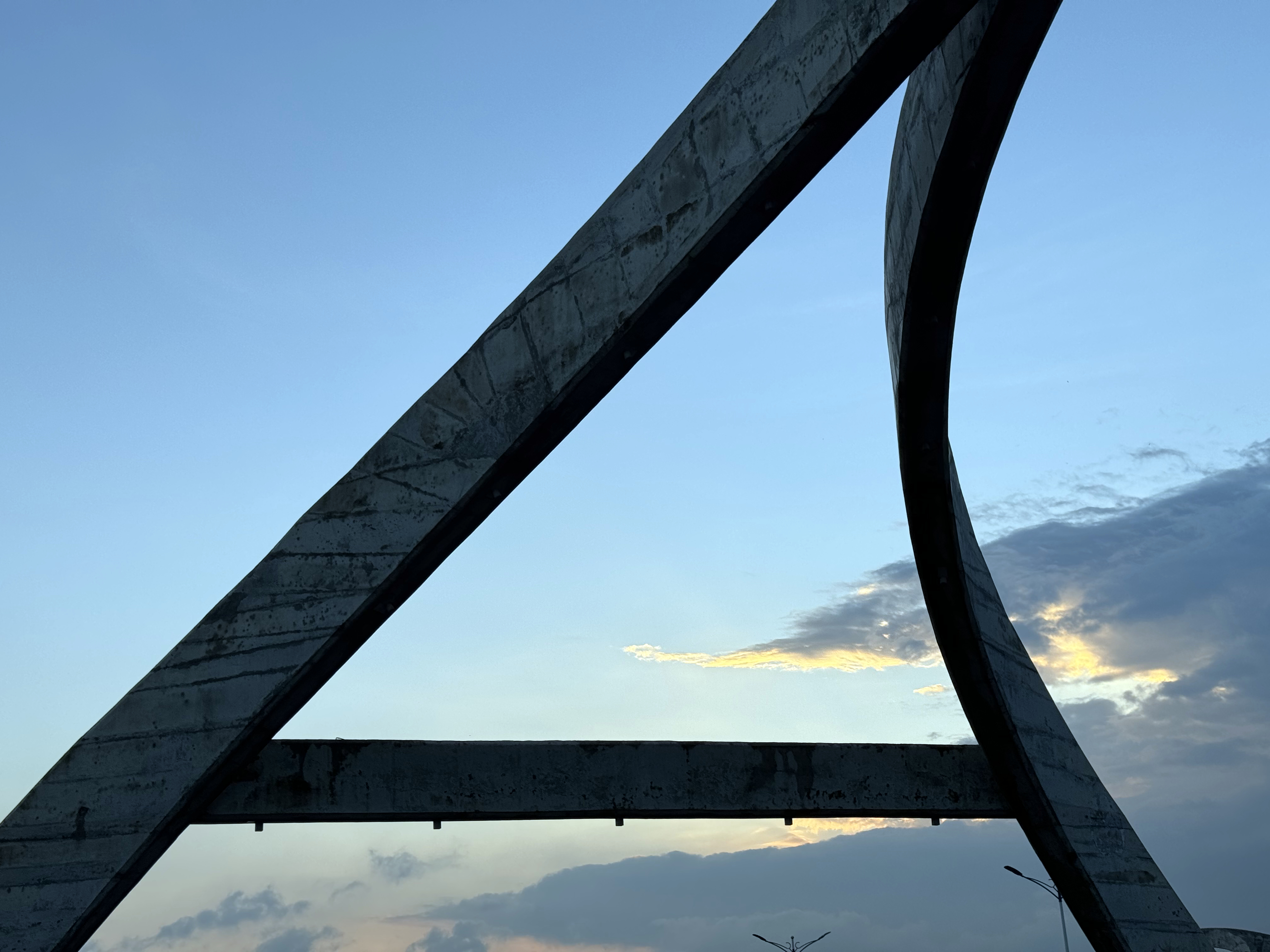 A large, curved concrete structure showcasing modern architectural design against a clear blue sky.