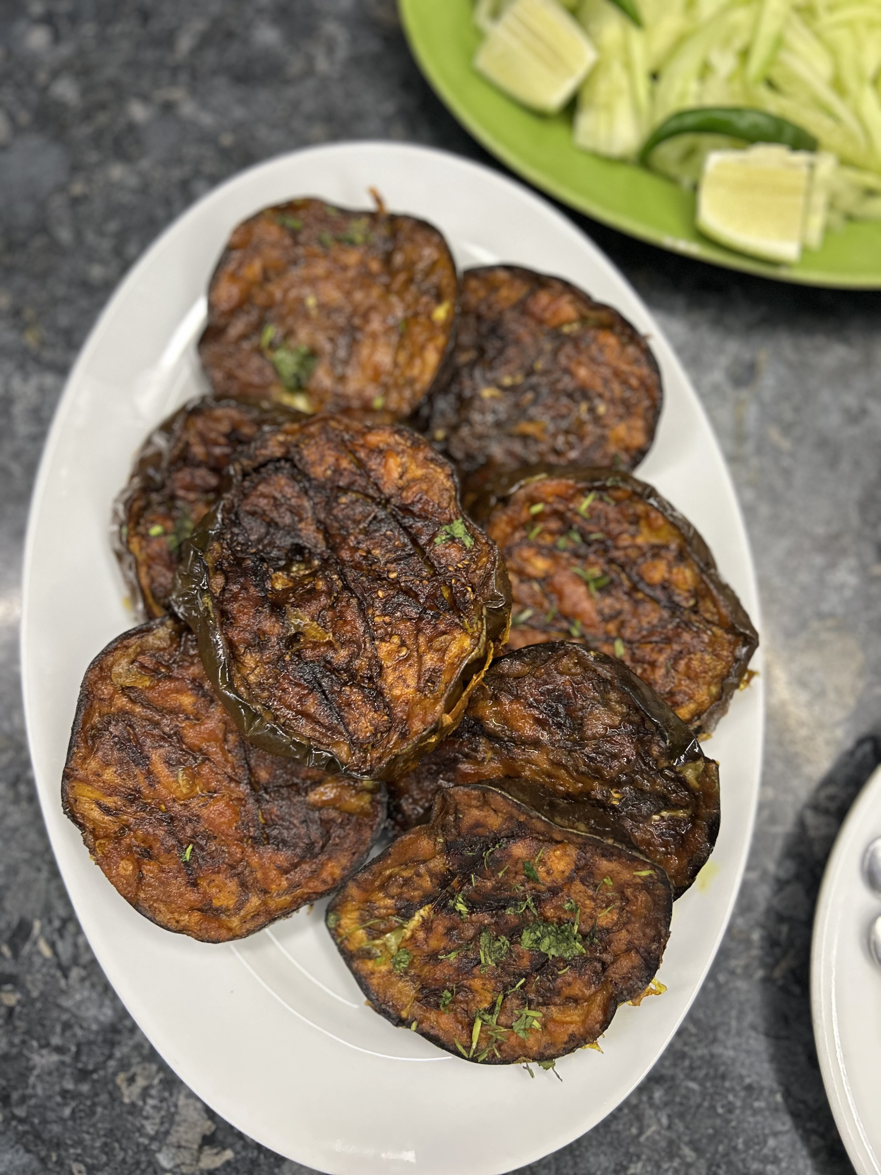 Round grilled meat patties served with lime, cucumber, and green chilies.