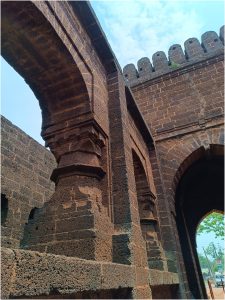 Boro Darwaja (Pathar Darwaja) in Bishnupur, featuring ancient stone walls, thick pillars, arches, and a crenellated parapet under a cloudy sky.
