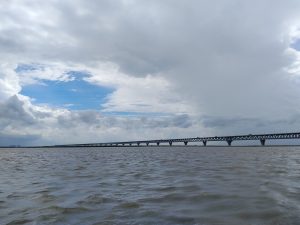 The Padma Bridge extending across the wide Padma River under a cloudy sky 