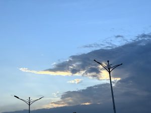 A street light silhouette stands against a backdrop of a cloudy sky, creating a dramatic contrast.