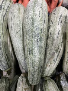 
Striped green zucchini with smooth, shiny skin.