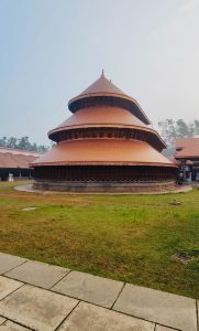 The prominent three tiered apsidal sanctum and copper plated tiered roofing of the Madhur Sree Madanantheswara Siddhivinayaka Temple, Kasaragod